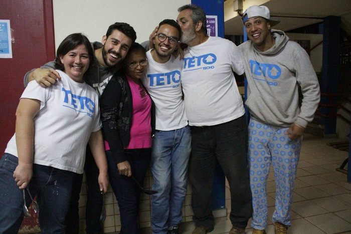 Lucas e voluntários ao lado de moradores da comunidade ao fim de um mutirão